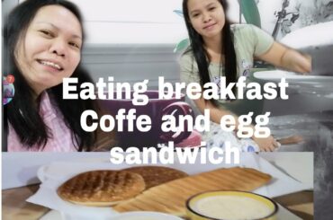 Eating breakfast coffee and egg sandwich