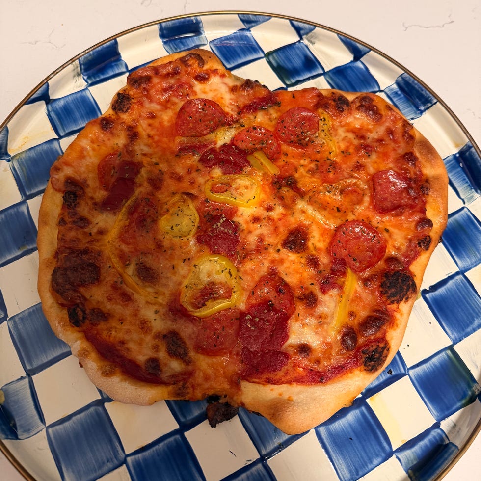 Heart-shaped pepperoni pizza on a blue and white checkered plate. Heart-shaped pepperoni pizza on a blue and white checkered plate.