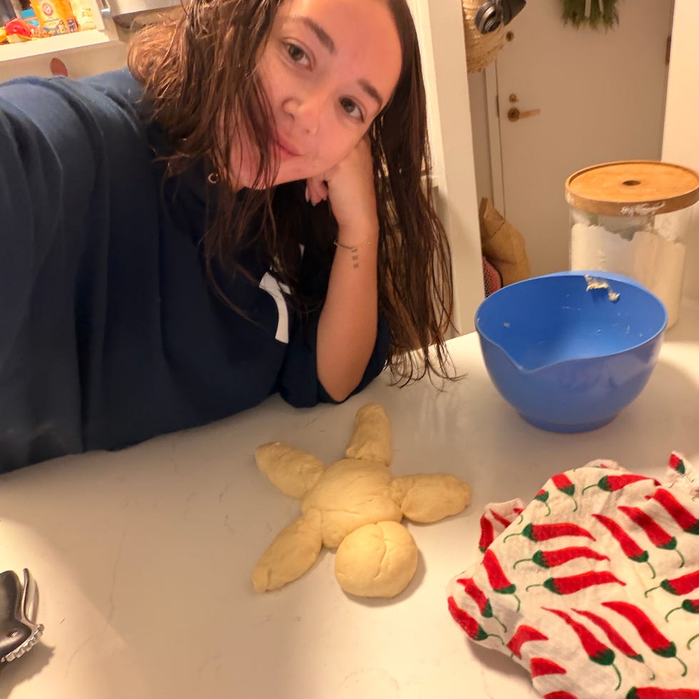 A person with wet hair smiling near a countertop with dough shaped like a star and a blue mixing bowl.
