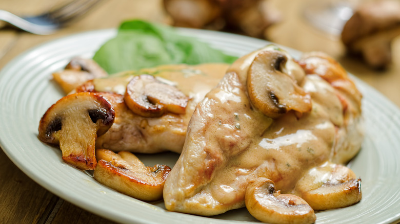 Chicken covered in a creamy sauce with mushrooms